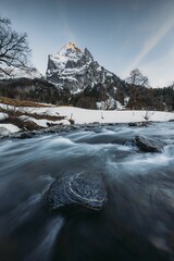 Long exposure of streaming mountain spring water in the background of Klein Wellhorn, Switzerland