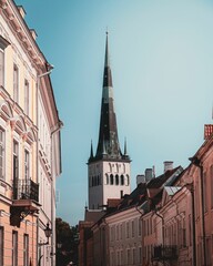 Vertical shot of cathedral's tower behind buildings in the old town of Tallinn