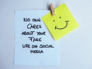 No one cares about your fake life on social media with a yellow smiley note on a white background