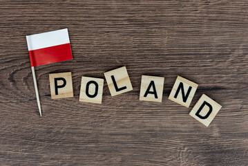 Fototapeta na wymiar Poland - wooden word with polish flag (wooden letters, wooden sign)