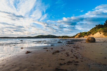 Scenic view of Moeraki Boulders Beach in Hampden, New Zealand on a cloudy day