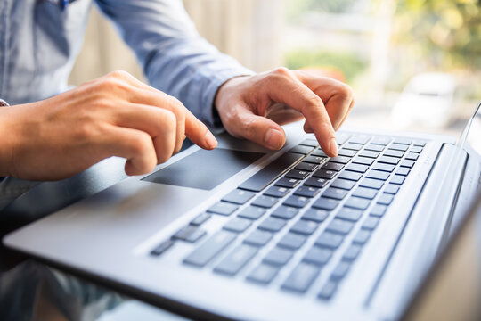 Image of male hands typing on keyboard, selective focus.