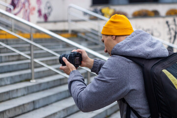 Photographer taking picture with professional camera on city street