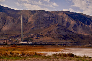 A copper smelting plant and it's 1.215 foot high smokestack, at the base of the Tooele mountains...