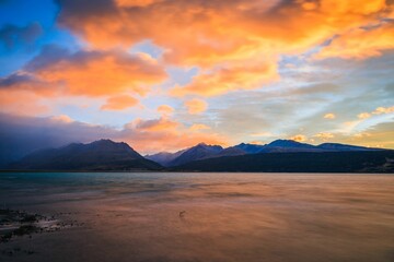 Long exposure of Lake Pukaki against mountains in Glentanner, New Zealand at sunset