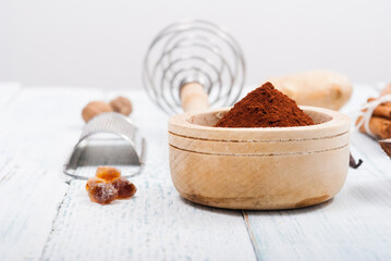 Fototapeta premium pile of cocoa powder, sugar and dessert ingredients, kitchen utensils on old white wooden