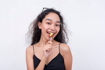 A lively and perky asian woman holding a lollipop. Isolated on a white background.