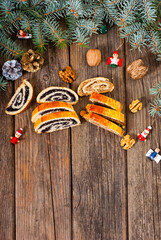 poppy and walnut roll cakes, santa and angel decorations, pine branch garland, old wood table