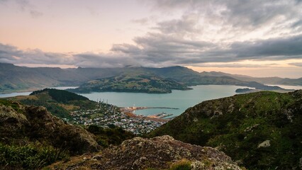 View of Lyttelton with coast surrounded by green mountains. New Zealand.