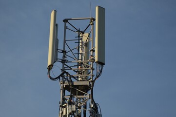 A Telecommunication antenna mast with blue sky background, France