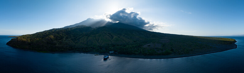 The sun rises behind the beautiful volcano of Sangeang, found just outside of Komodo National Park, Indonesia. The reefs and black sands that surround the island support a wide variety of marine life.