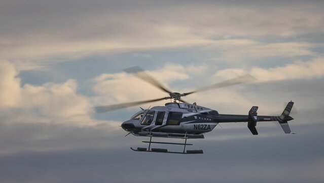 Aerial view of  Bell 407, a utility commuter helicopter in the clear blue sky