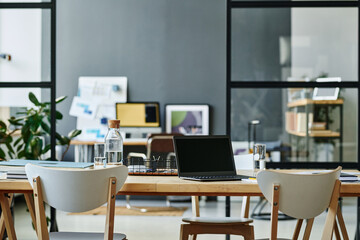 Workplace of modern creative designer or other employee with laptop standing on desk surrounded by...