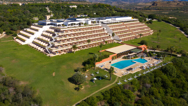 Aerial view on the modern Mangia's resort built in a pyramid shape near the sea. It has a swimming pool and a large park. Sciacca, Italy - November, 2022