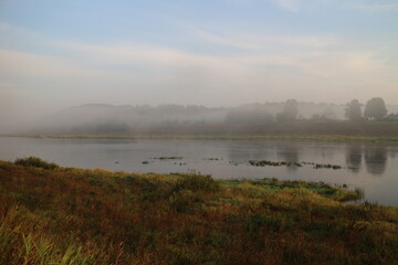 foggy morning over river in summer in countryside