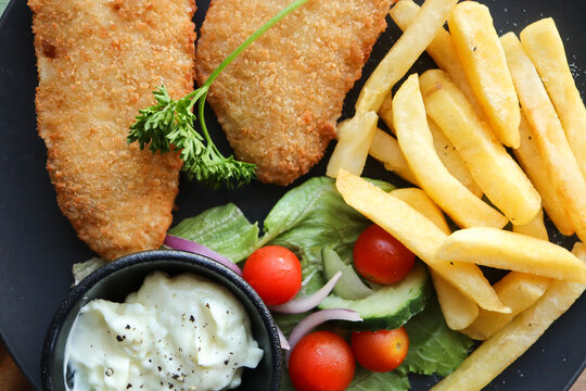 fish and chips. Crumbed hake fillets with chips and salad 
