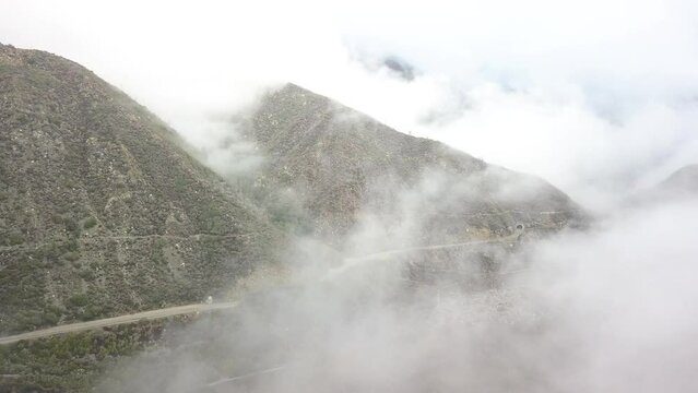 View of the misty road and mountains from a drone. Glendora, California, USA.