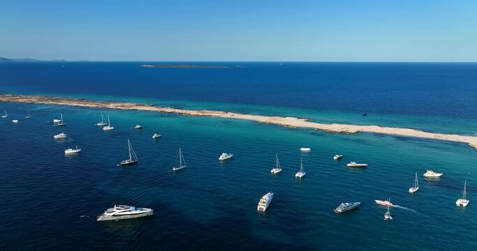 Aerial view of the beaches of Formentera island, Spain. Clear blue water of the Mediterranean Sea full of yachts.