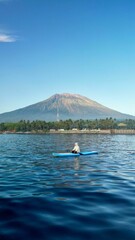 Aerial view of a person in a kayak floating on the water near the volcano in Bali, Indonesia