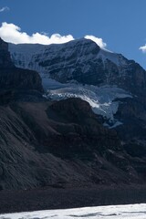 Vertical shot of rough mountains covered in snow in the daytime