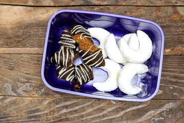 Oriental Algerian sweet cookies ( kaab el ghazal and chocolate named bniwen in lunch box  on wood...