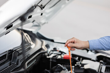 car mechanic Side view of mechanic checking engine oil level in car mechanic checking engine oil