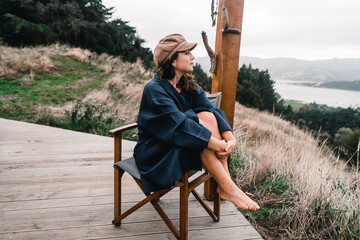 blue-eyed caucasian girl happy looking contemplating the beauty of the landscape wearing a bathrobe...