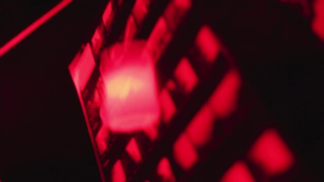 Caucasian young man developing analog photography in a dark room.