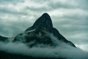 Rocky mountain peak in the clouds. Norway. - obrazy, fototapety, plakaty