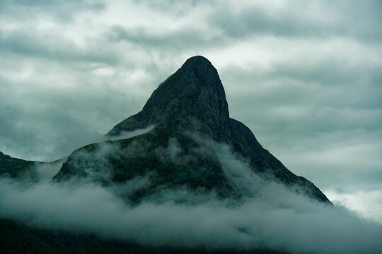 Rocky mountain peak in the clouds. Norway.