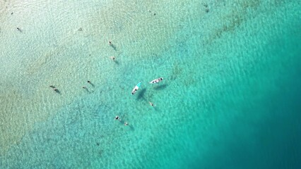 Fototapeta premium Aerial view of surfers on a calm sea during summer
