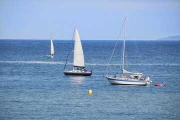 Closeup shot of white boats sailing along the Galician coasts of the Cantabrian Sea