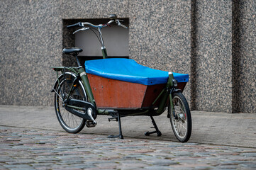 Fototapeta na wymiar Cargo bicycle for fast city delivery parked in front of a house