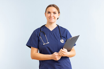 Female nurse or doctor with clipboard against a blue background