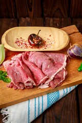 Cherry in a bowl and corned beef slices on a wooden cutting board