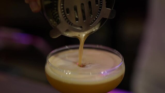 Barman Pouring Passionfruit Cocktail Into A Saucer Glass