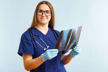 Female doctor examining xray image diagnosing injury on blue background