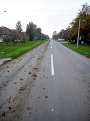 View on the road full of mud and garbage.