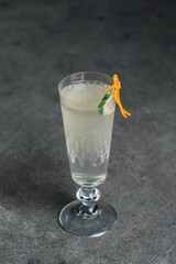 cocktail in flute glass with lime and orange mermaid garnish