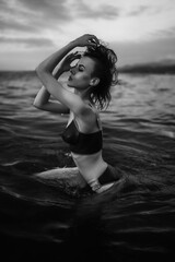 Black and white portrait of a sexy beautiful woman in the sea. Natural beauty of a young pretty girl with sexy body, clean skin and dark hair.