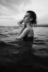 Black and white portrait of a sexy beautiful woman in the sea. Natural beauty of a young pretty girl with sexy body, clean skin and dark hair.