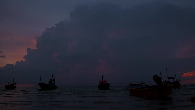 Small fishery boats with  dark rain cloud and flash lightning in 4K footage.