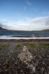 Pebbles stacked on the rocky lake coast