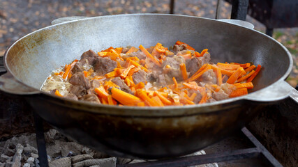 Meat with carrots fried in a pan