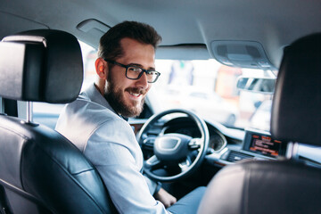 Attractive elegant man in business suit driving car