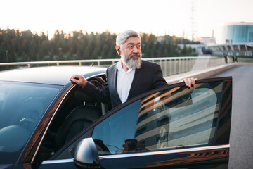 Portrait stylish, handsome man near car outdoors