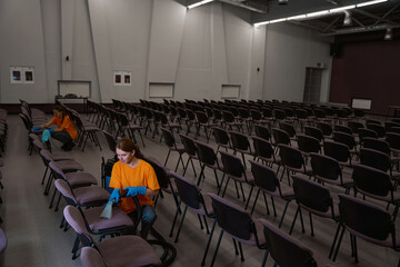 Certified cleaning service workers desinfecting a big room of chairs