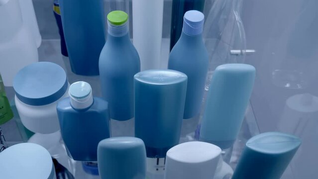 Rows of different new plastic jars, bottles, vials different colors, shapes and sizes for medical, cosmetic, chemical or food industry. Shot in motion. Closeup
