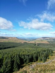 Fototapeta na wymiar Vertical aerial view of Meikle Bin Hill, Carron Valley, and nearby green land in rural Scotland