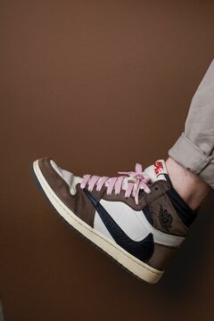 Vertical closeup of Nike Air Jordan 1 High 'Travis Scott' with pink shoe laces.